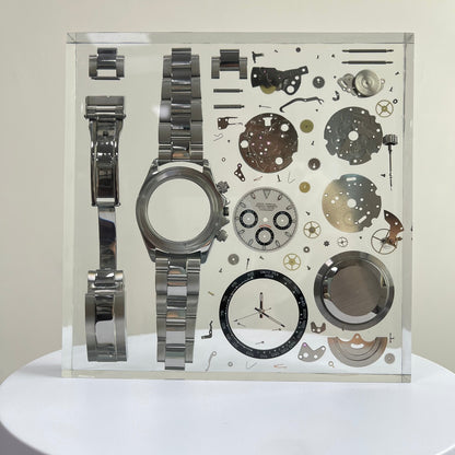 Deconstructed Silver watch with mechanical components inside a resin block
